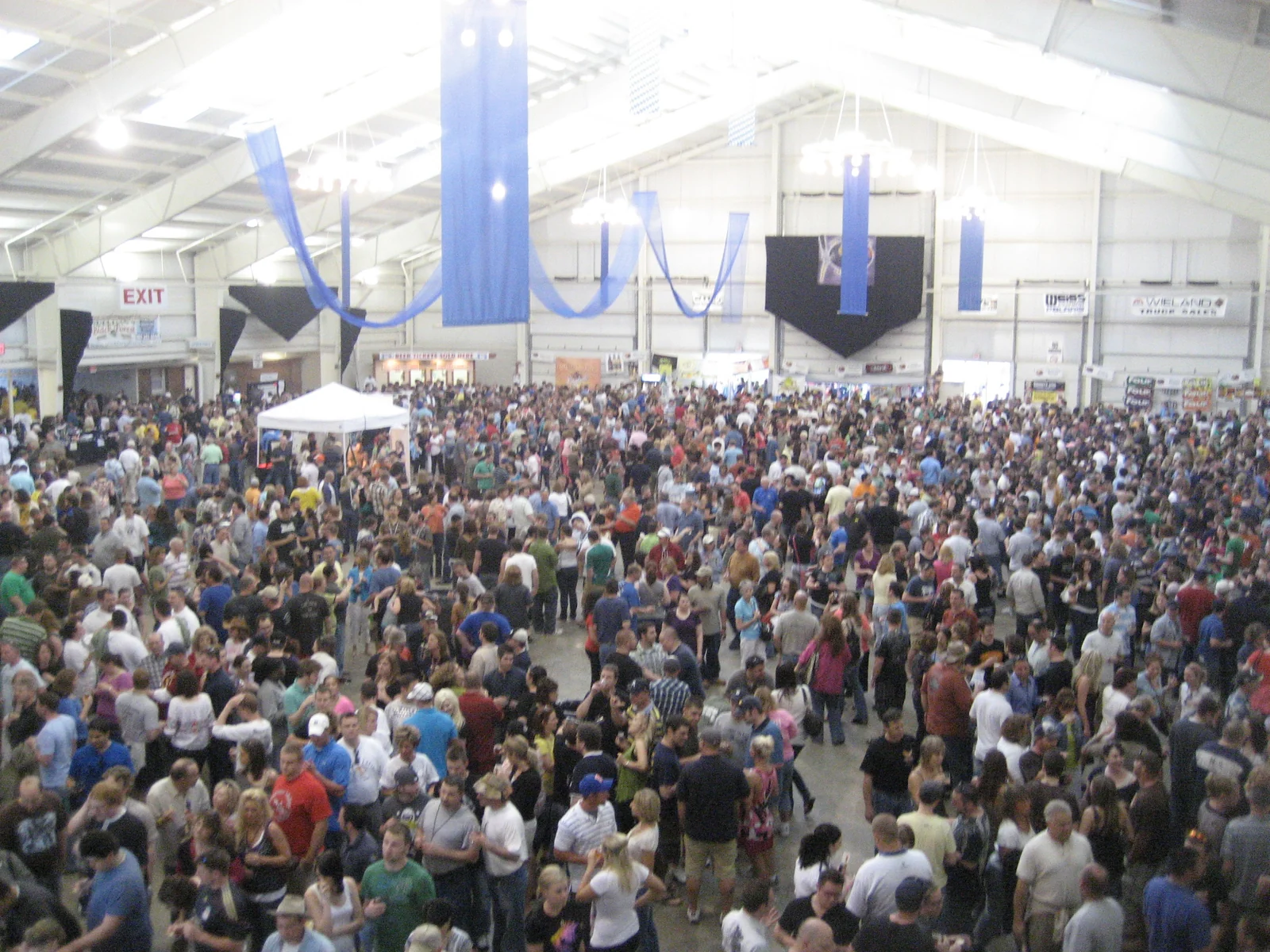 Guests exploring brewery booths inside the busy World Expo of Beer pavilion